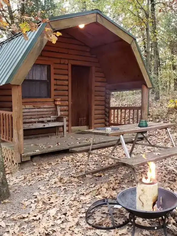 A camp cabin with its own fire pit out front